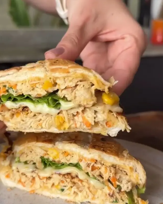 Sándwich tostado con relleno cremoso y vegetales
