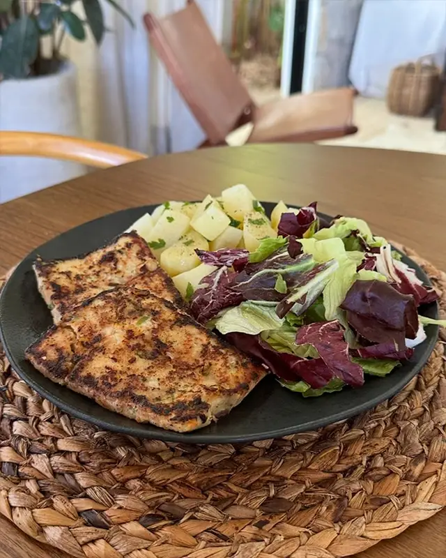 Comida servida en un plato con ensalada