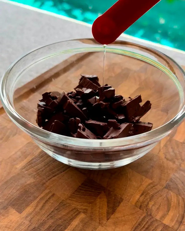 Chocolate picado en un recipiente de vidrio durante la preparación
