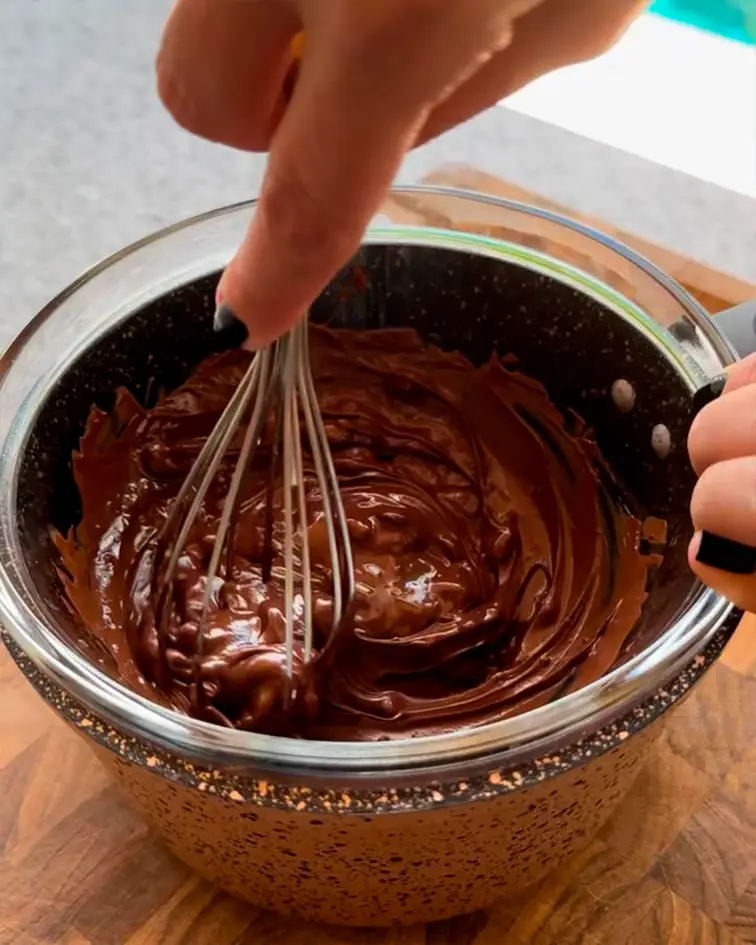 Chocolate mezclándose con un batidor de varillas en una olla